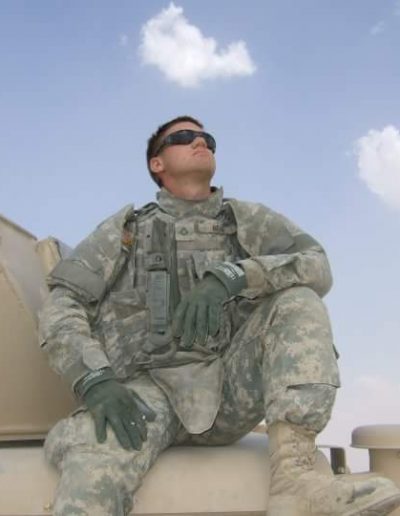 A soldier sitting on top of a tank.