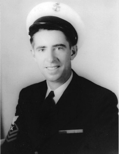A man in uniform is smiling for the camera.