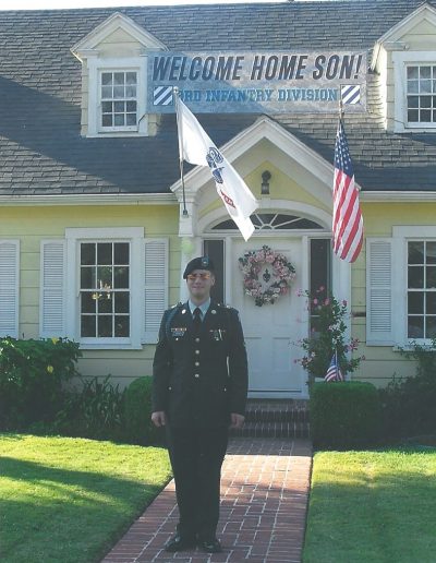 A man in uniform standing outside of a house.